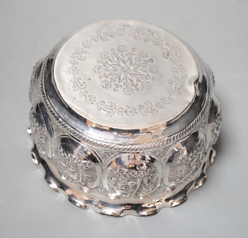 An Indian embossed white metal bowl, decorated with various scenes, diameter 16.5cm, 9oz.